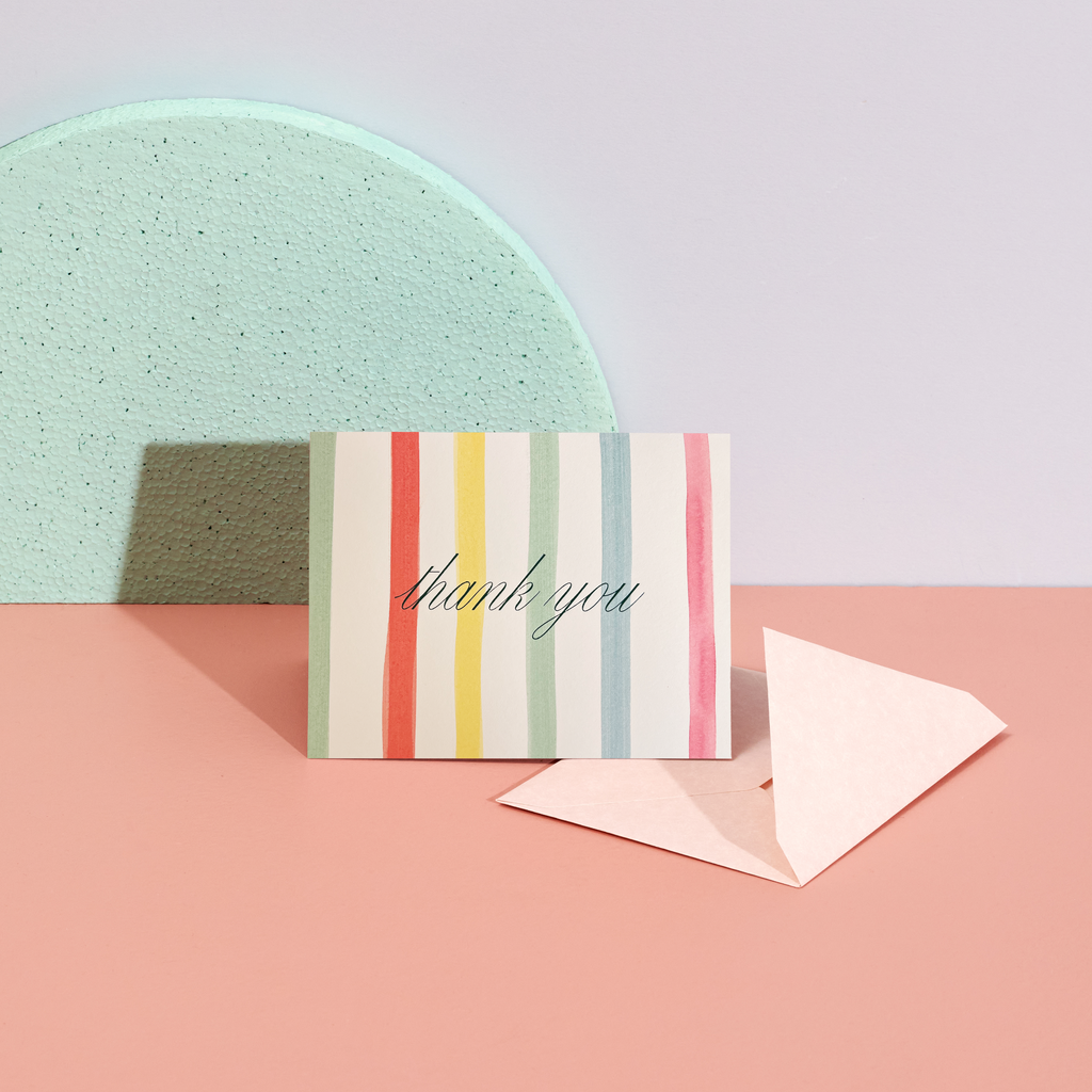 Striped card with 'thank you' text on a pink and green background
